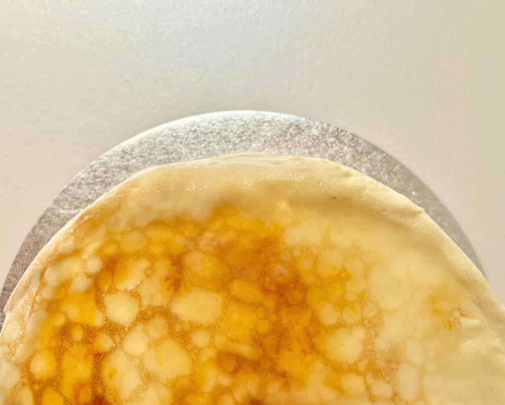 Close-up of a creme brulee pancake cake on a light background.