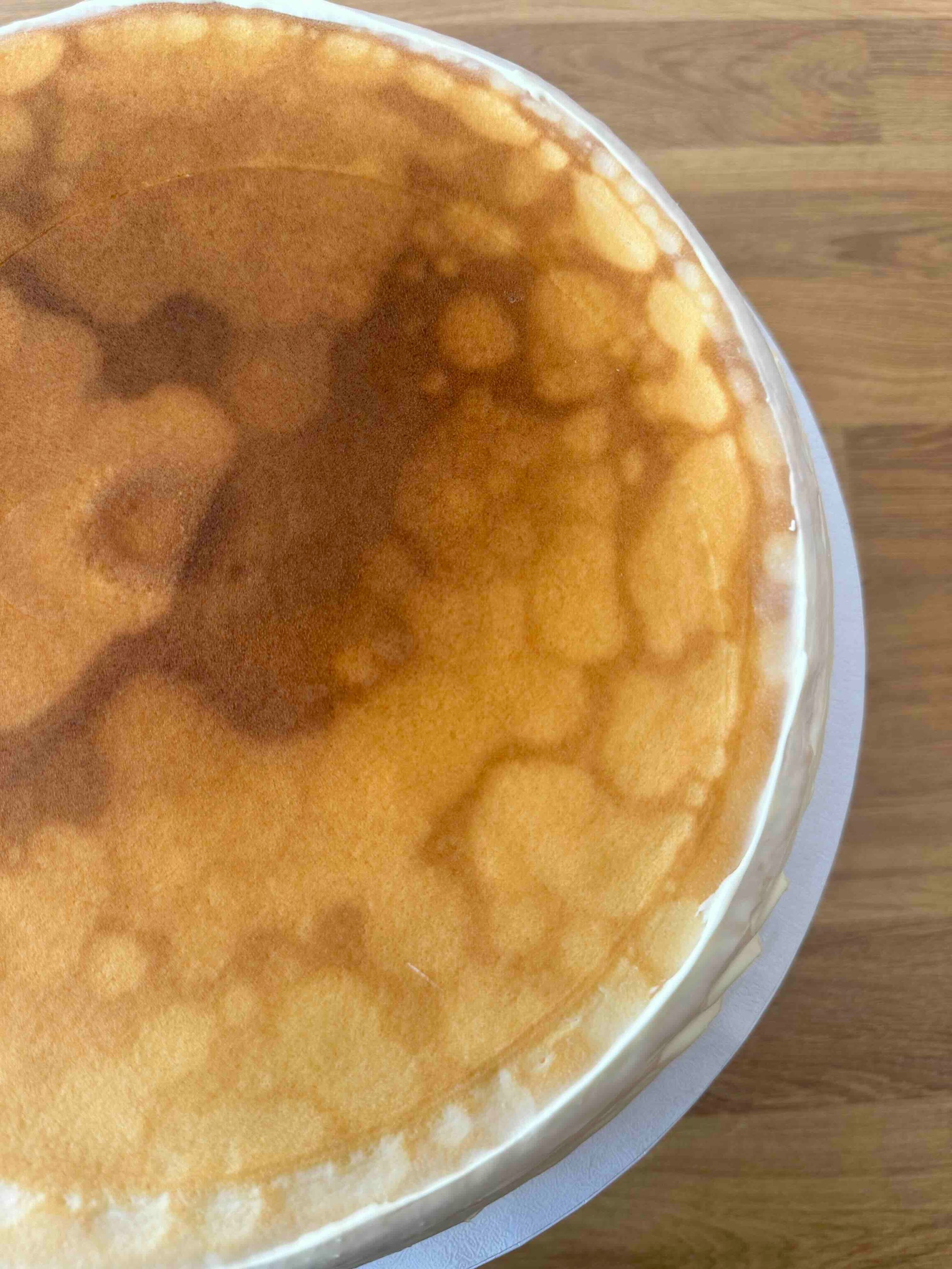 A close-up top-down view of a creme brulee pancake cake, set on a wooden surface.