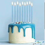 Birthday cake with blue icing and 9 lit blue candles on a light blue background.