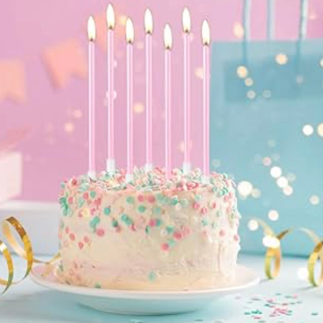 Birthday cake with seven lit pink candles on a colorful background.