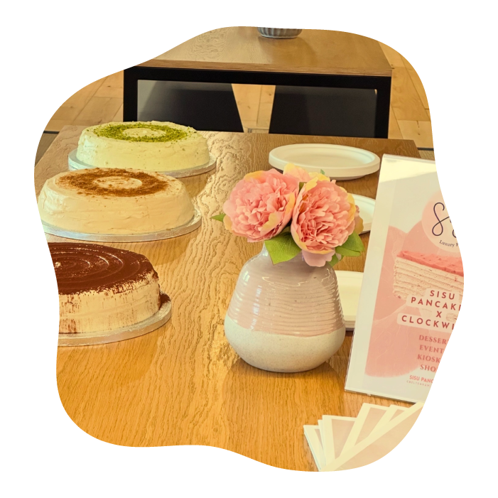 A wooden table at a dessert shop or cafe setting with three layered pancake cakes
