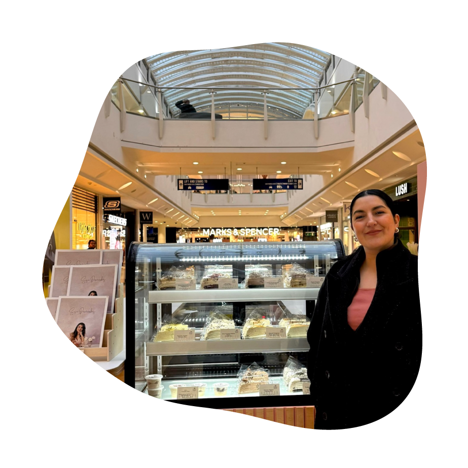 Woman standing in a shopping mall with a bakery display case in the background