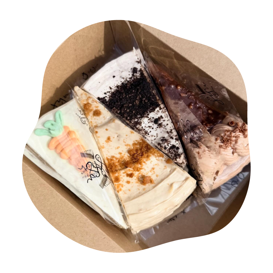 Three types of pancake cake slices in a cardboard box on a white background