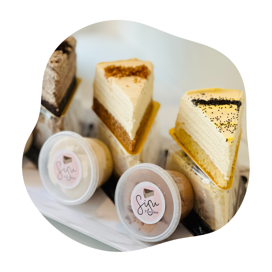 Three slices of layered pancake cakes with a brand logo on a white plate.